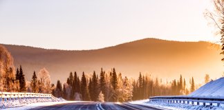 Icy winter road with mountains in background