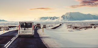 Campervan on the ring road with snow on the shoulder and a pink sky