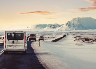 Campervan on the ring road with snow on the shoulder and a pink sky