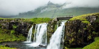 Two red chairs overlooking a waterfall in Iceland during summer season