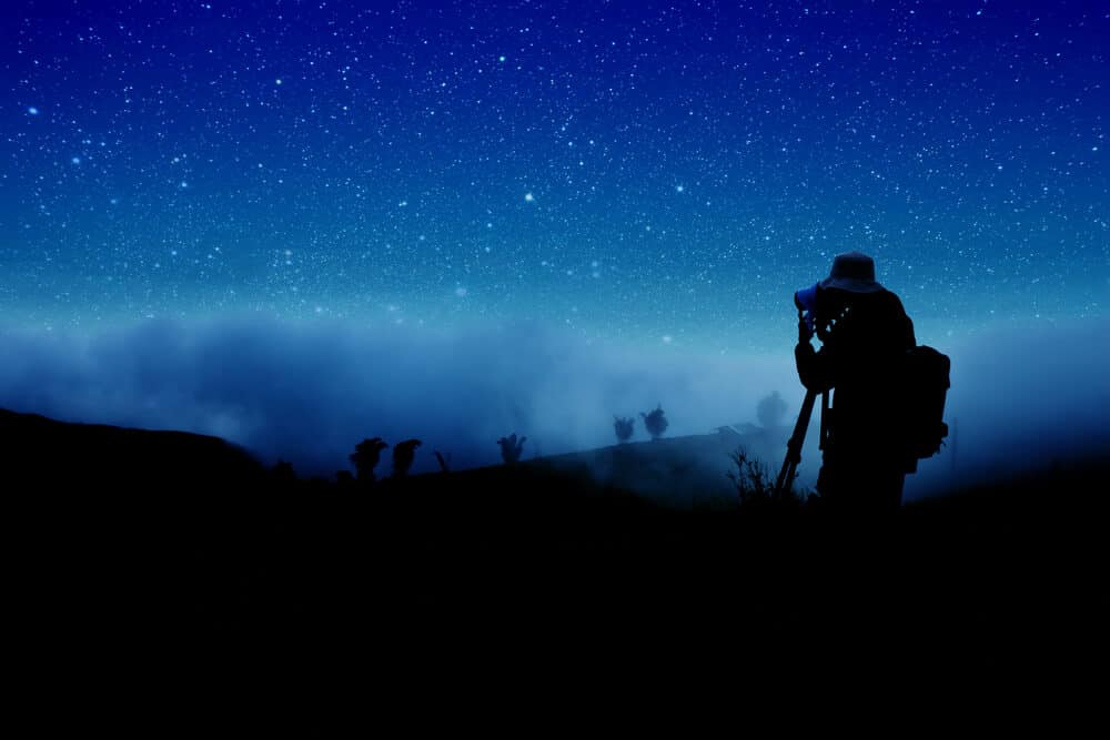 Man preparing to take photos of a starry night sky