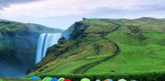 Multiple tents set up at Skógafoss waterfall for camping in Iceland in September