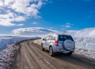 Car driving on icy, ashy, sandy roads in Iceland