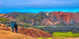 Two hikers stop to admire the beautiful rhyolite mountains in Landmannalaugar