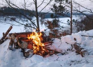 Campfire on snow during camping trip in Iceland