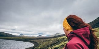 Female tourist looking at the mossy landscape while camping in Iceland
