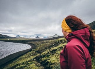 Female tourist looking at the mossy landscape while camping in Iceland