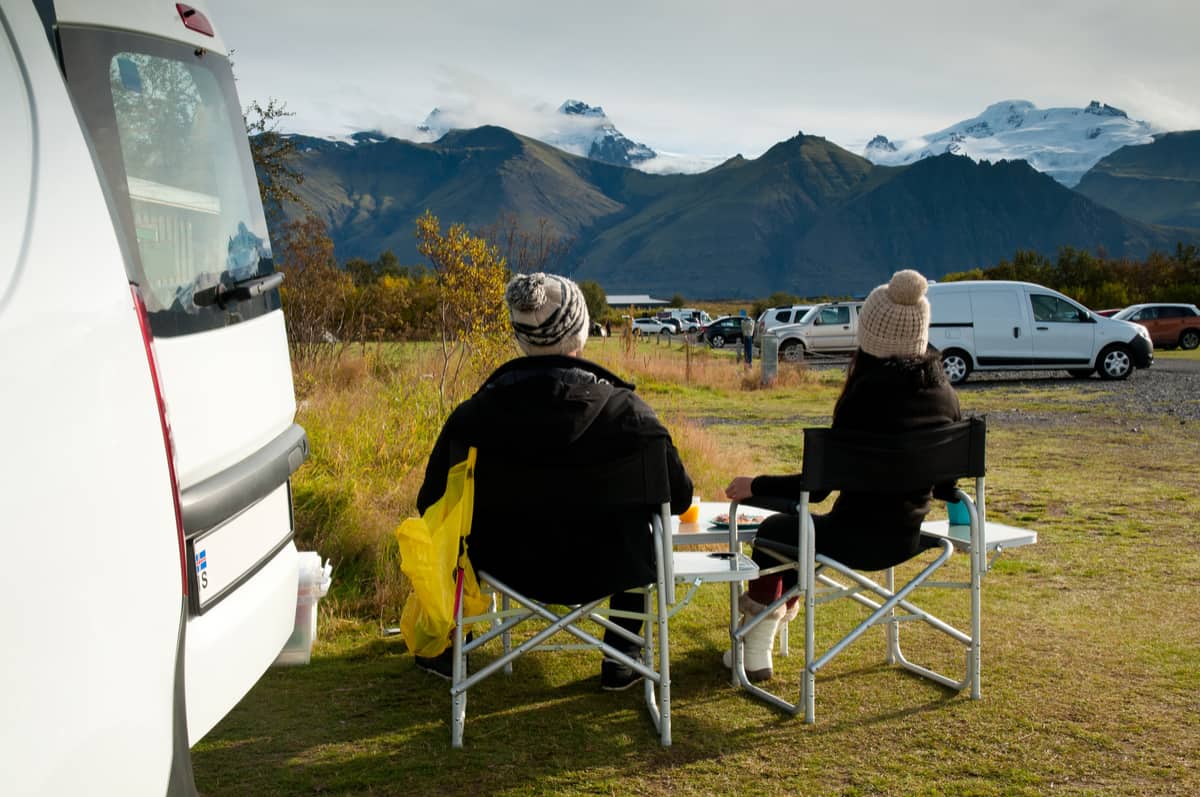 Couple enjoying the view outside their campervan during Iceland camping trip